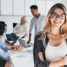 blonde-female-executive-posing-with-smile-arms-crossed-during-brainstorm-with-managers-indoor-portrait-european-student-spending-time-hall-with-asian-african-friends